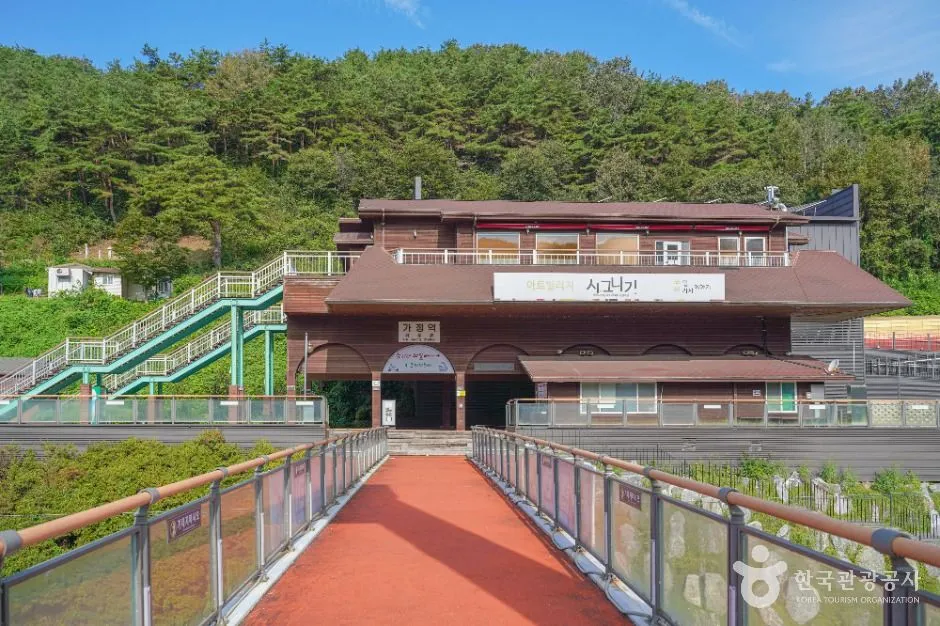 철길 옆에 자리한 가정역 역사와 육교형 진입로
