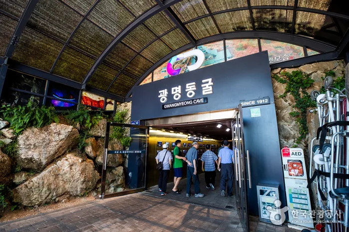 광명동굴 간판과 입구로 들어서는 방문객들