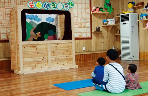 아이들이 앉아서 인형극을 관람하는 섬진강도깨비마을 공연장 내부