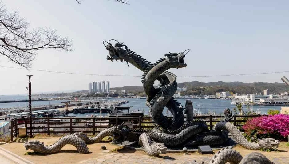 항구를 배경으로 한 용 모양 조각 조형물