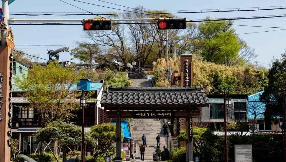 가옥거리 입구 쪽에서 계단과 일본식 지붕의 출입문이 보이는 장면