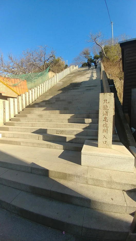 푸른 하늘 아래 돌비석이 선 가파른 석조 계단