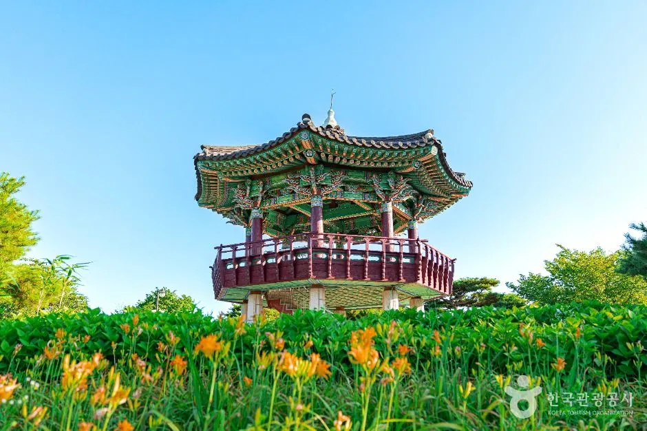 주황색 원추리 꽃밭 위로 솟은 한국식 정자