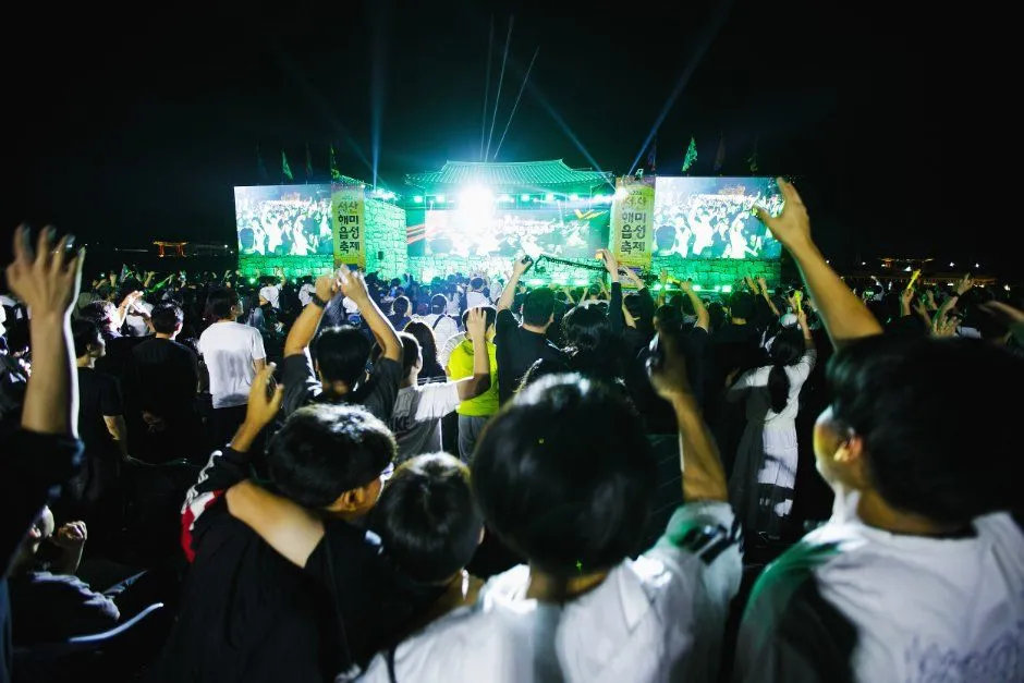 야간 무대 앞에 관람객이 가득 모여 환호하는 축제 현장