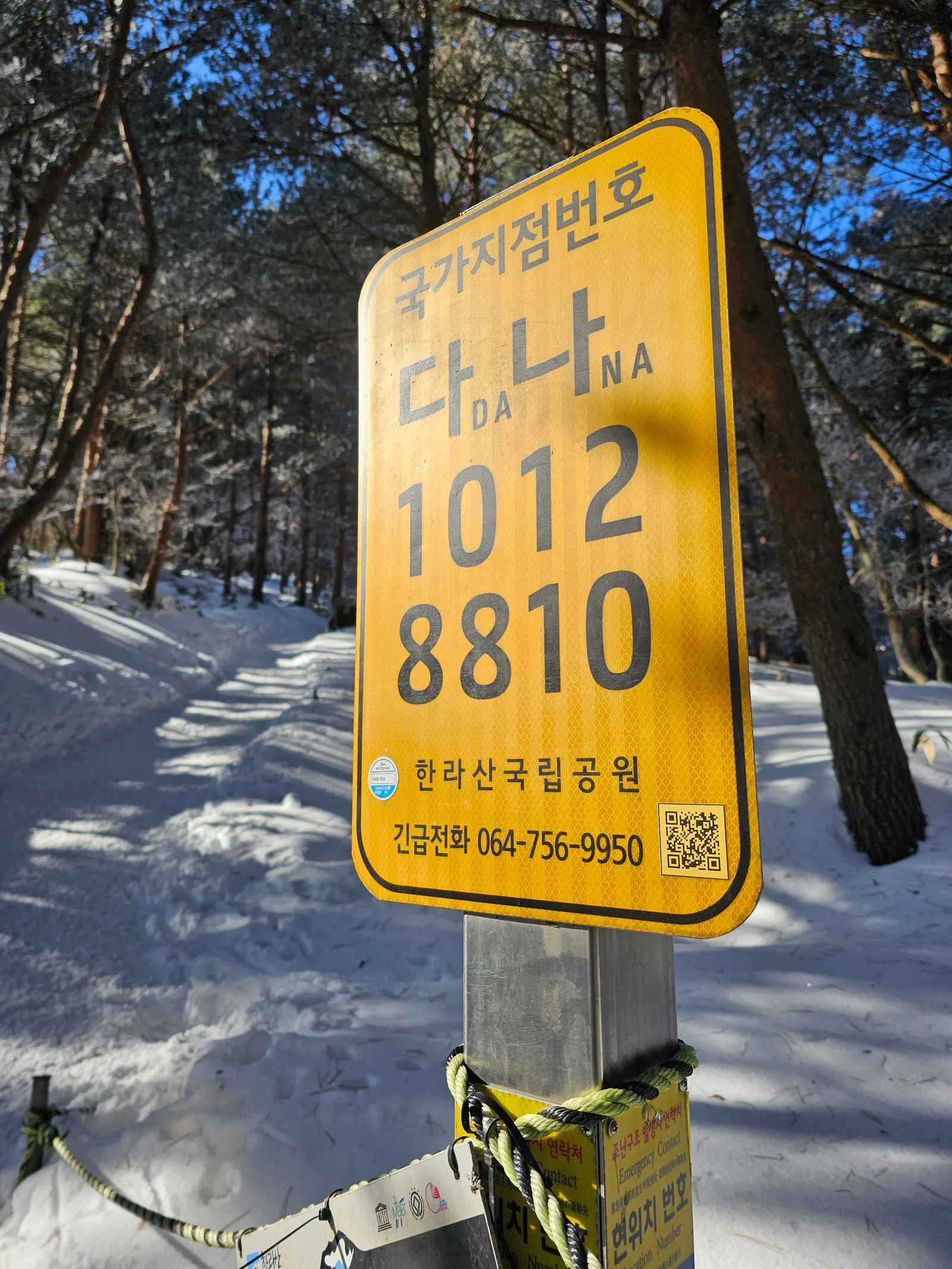 한라산국립공원 탐방로의 위치 표시 안내판과 눈 덮인 숲길
