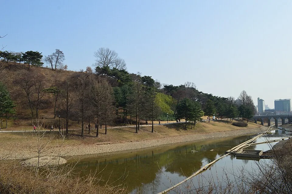 몽촌토성을 둘러싼 해자와 산책로, 멀리 보이는 빌딩