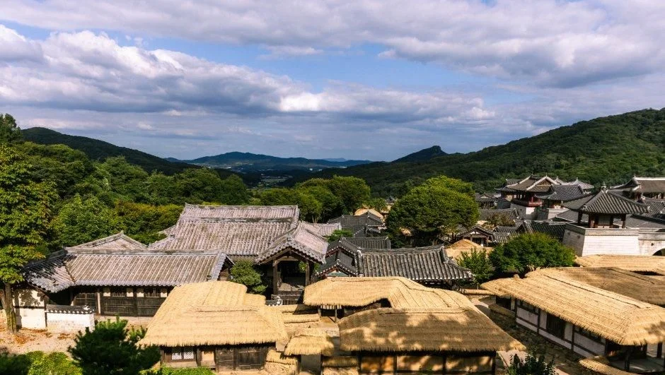 산자락 아래 초가지붕 마을이 내려다보이는 모습