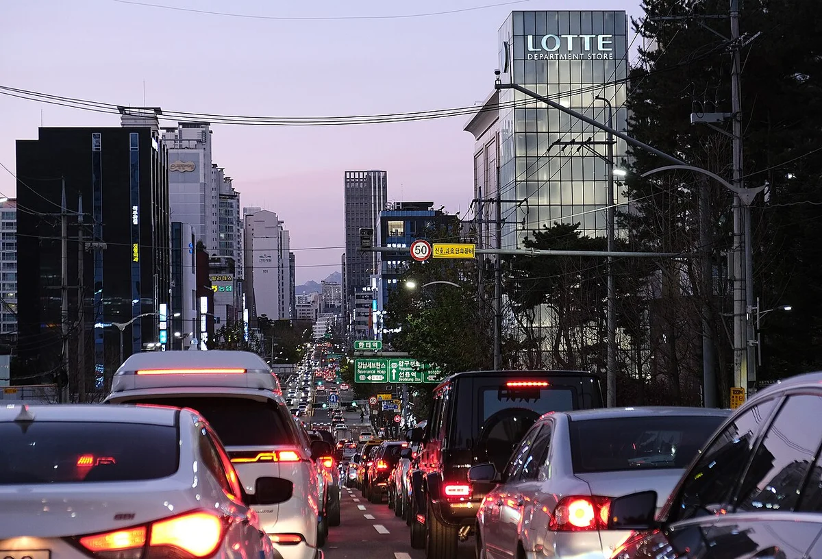 서울 강남 도로에서 저녁에 차들이 줄지어 서 있고 앞차들의 후미등과 제동등이 켜져 있는 정체 모습