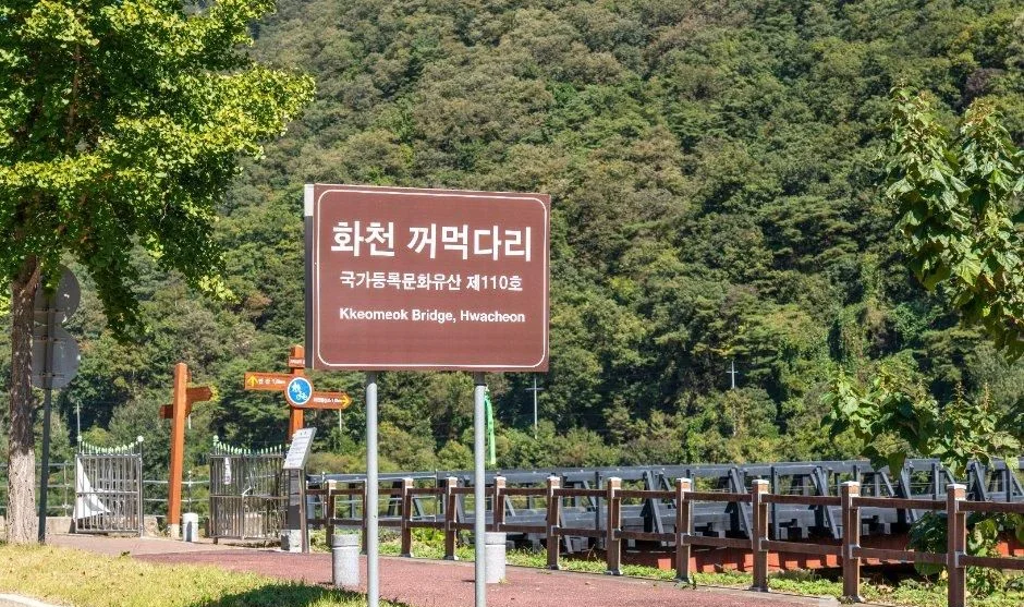화천 꺼먹다리 안내 표지판과 목조 다리 난간