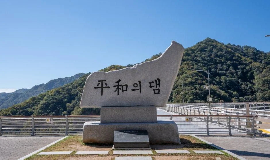 산을 배경으로 놓인 한자 평화의댐 표지석