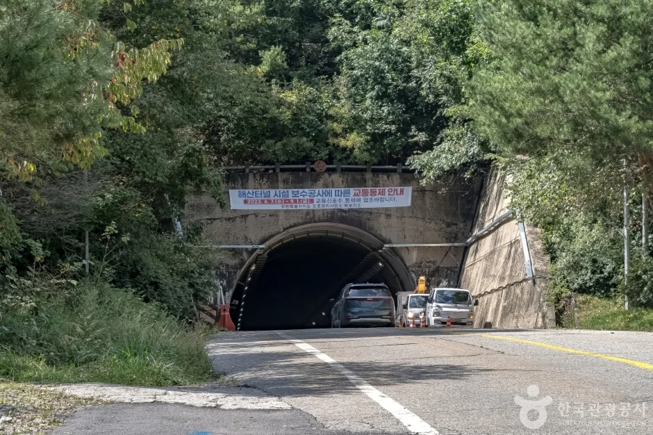 산자락 사이 도로 끝에 안내 현수막이 걸린 해산터널 입구