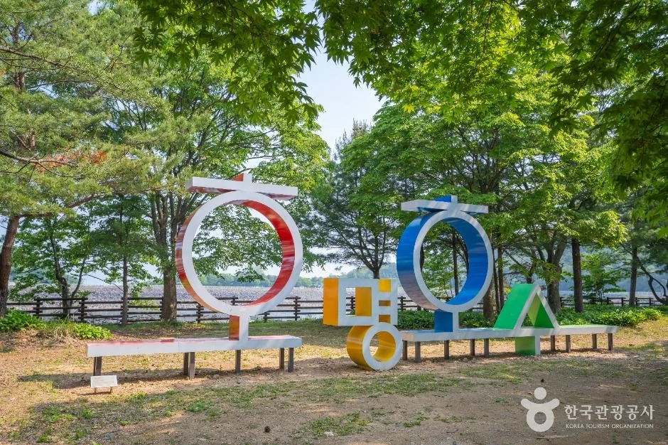 나무 그늘 아래 놓인 호명 글자 모양의 알록달록한 조형 벤치