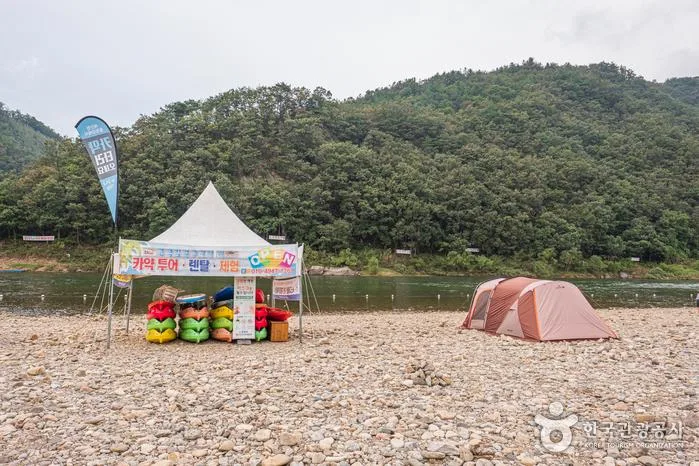 홍천강 자갈 강변에 설치된 텐트와 카약·래프팅 대여 부스
