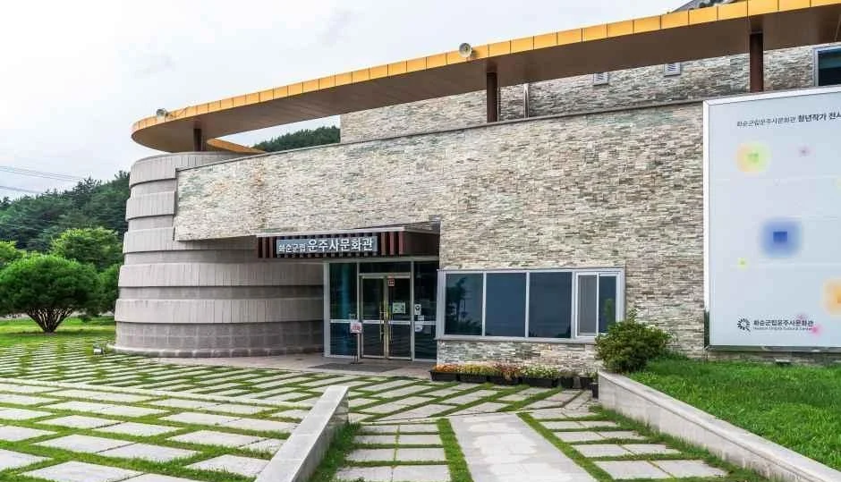 돌 외벽과 곡선 지붕이 있는 운주사문화관 건물 입구