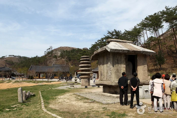 지붕 모양 돌 구조물 옆에 관람객이 선 탑 주변