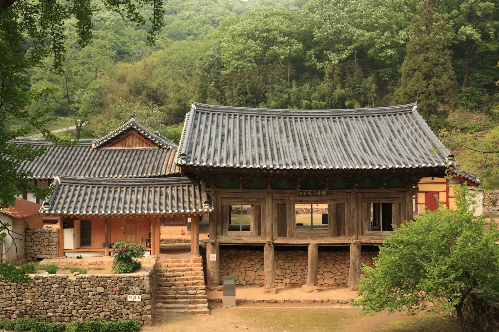 화암사 우화루 정면, 자연스럽게 휘어진 목재 기둥과 맞배지붕 아래 편액이 걸려 있다