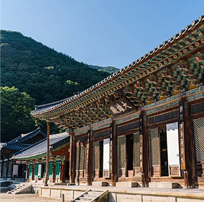 화엄사 각황전 처마 아래 단청과 현판, 맑은 하늘을 배경으로 한 모습