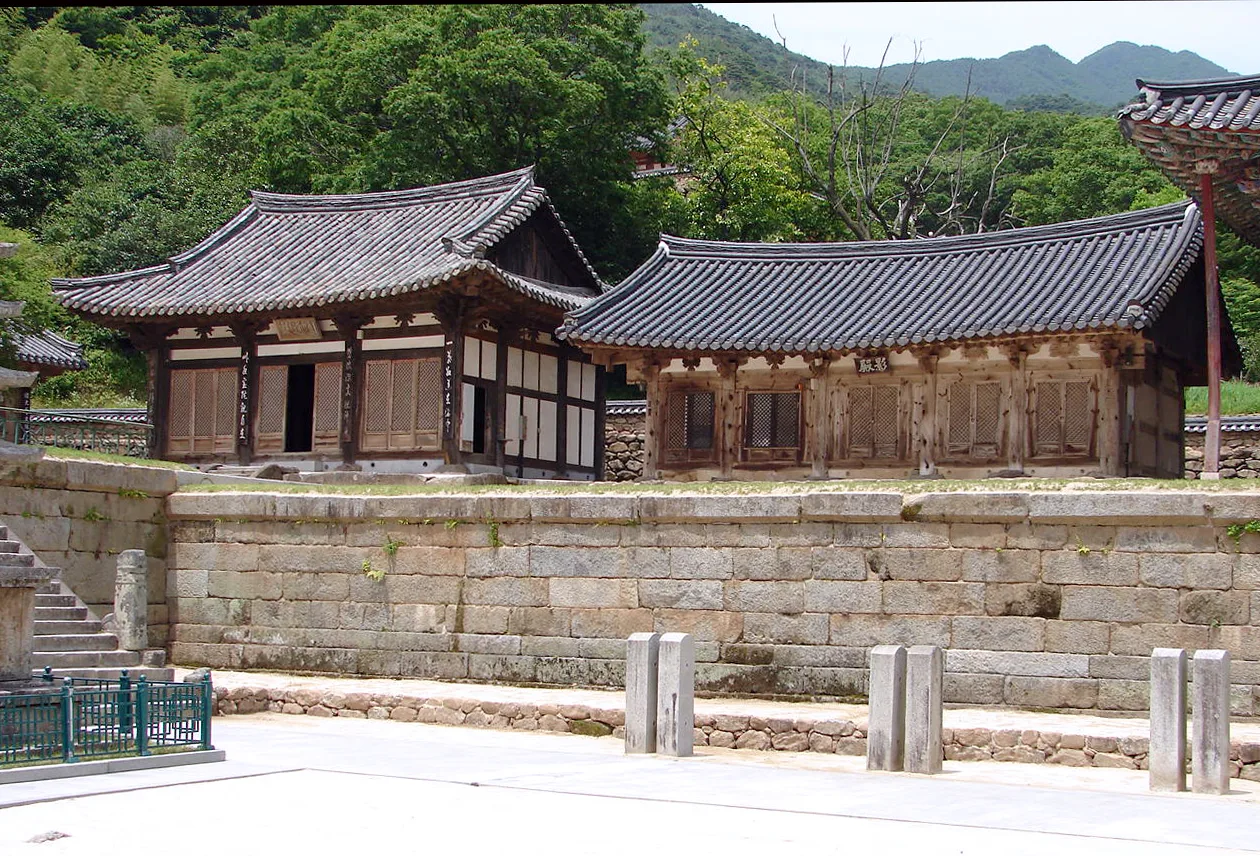 화엄사 요사채 건물과 돌담, 뒤편 산자락의 나무들