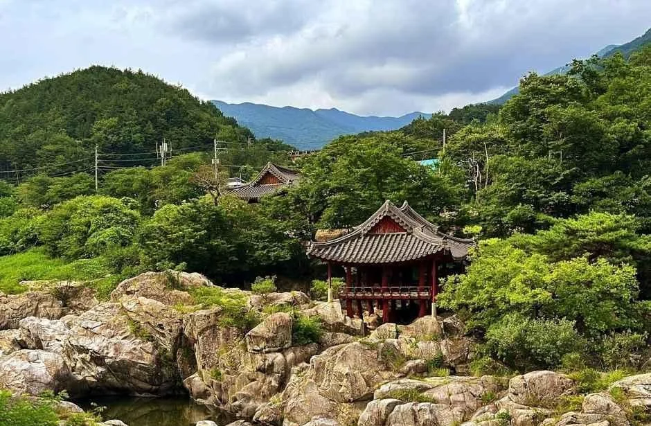 숲과 큰 바위 사이로 보이는 거연정 전경