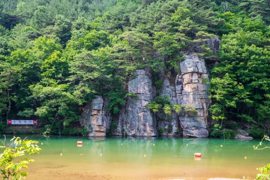 푸른 물웅덩이 뒤로 바위 절벽이 선 화양구곡 계곡
