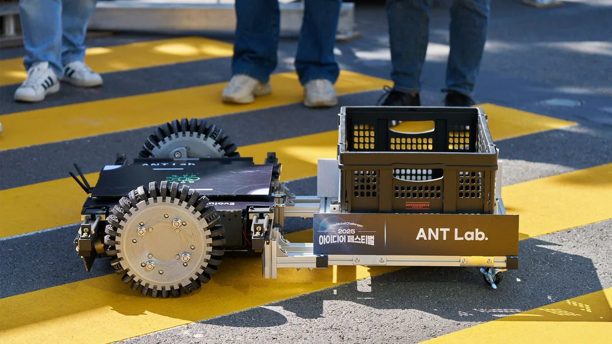 노란 줄무늬 도로 위에서 ANT Lab 표시가 붙은 바퀴 달린 시제품 로봇