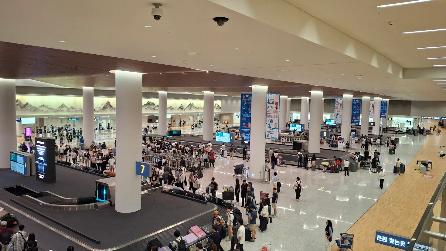 인천국제공항 제2여객터미널 입국장에서 수하물 수취대 주변에 승객들이 모여 있는 모습