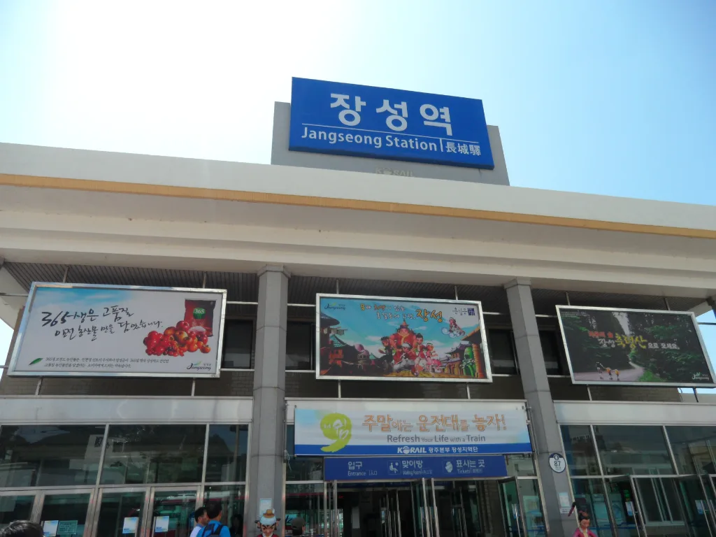 파란색 장성역 간판이 걸린 역사 건물 외관, 입구 위로 관광 홍보 배너들이 걸려 있다