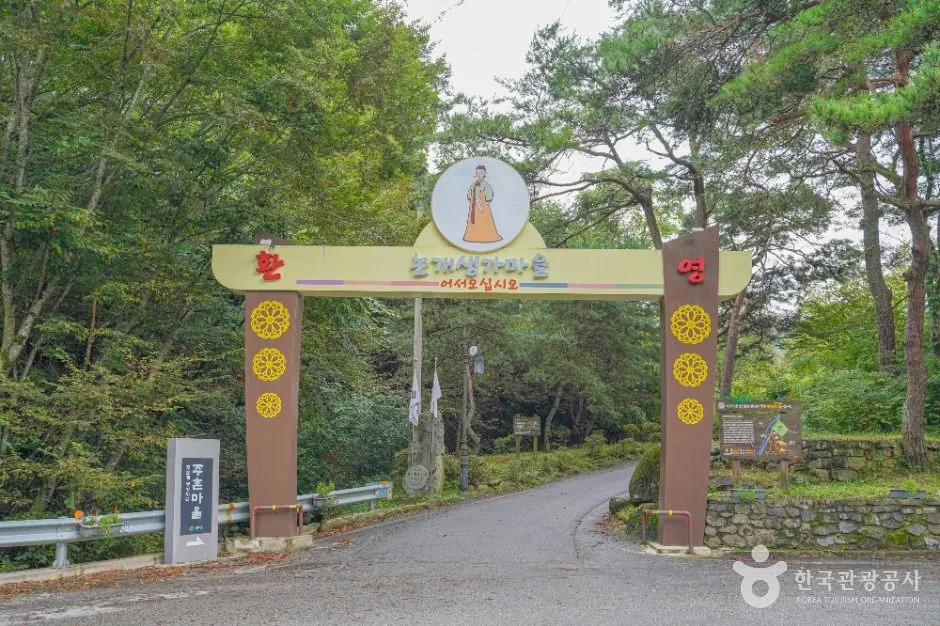 숲길 입구에 세워진 아치형 마을 입구 문