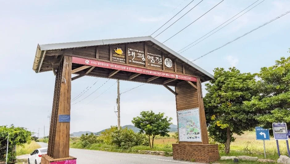 증도 입구를 알리는 목재 아치 간판과 도로
