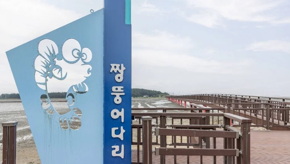 짱뚱어 그림이 그려진 파란 안내 표지와 목조 난간