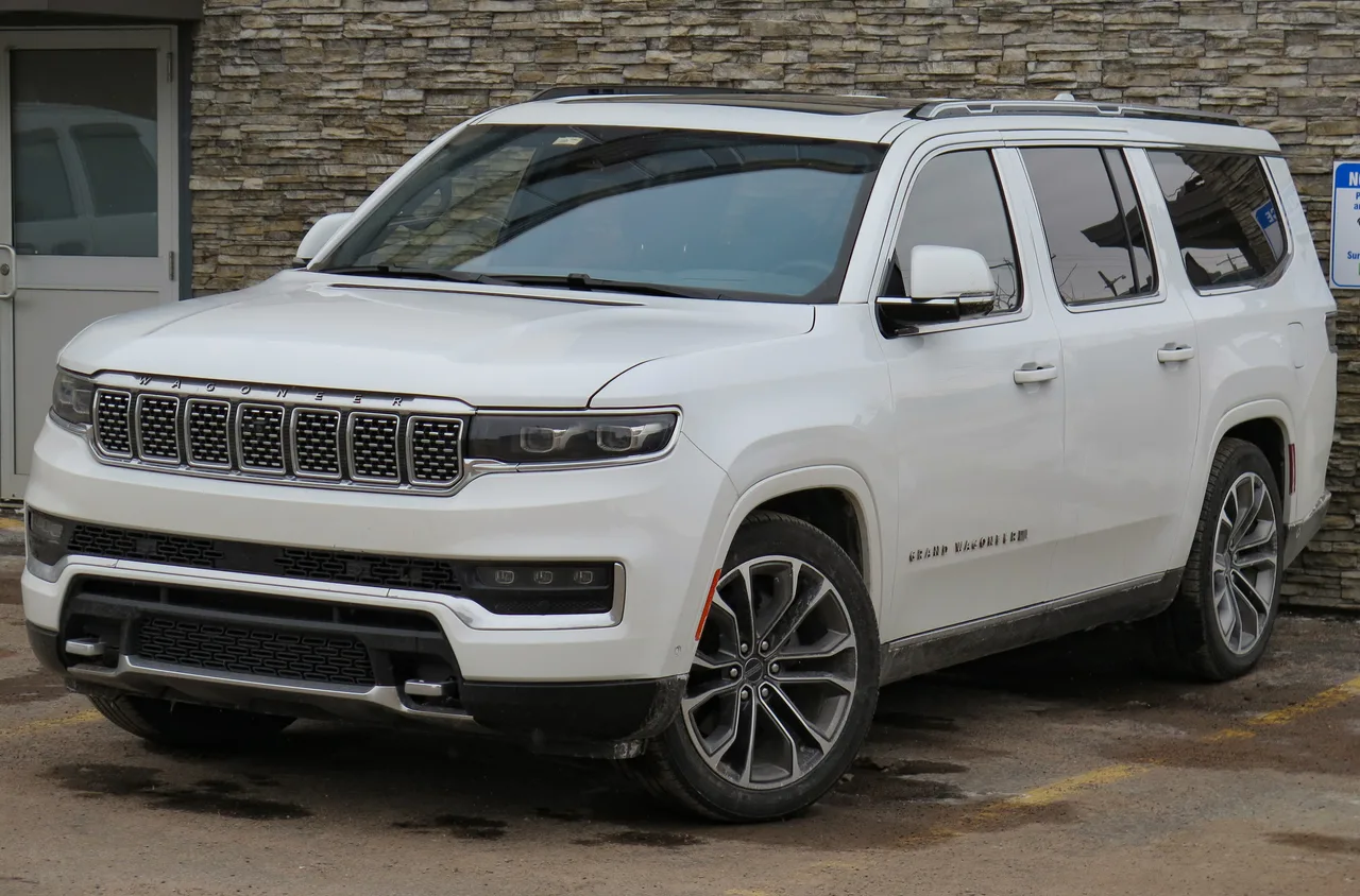 흰색 지프 그랜드 왜고니어 L의 전면 및 측면 모습, 3열 롱보디와 GRAND WAGONEER 레터링이 보인다