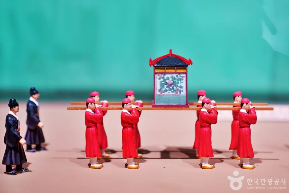 붉은 옷을 입은 인형들이 가마를 메고 가는 모습을 재현한 전시 모형