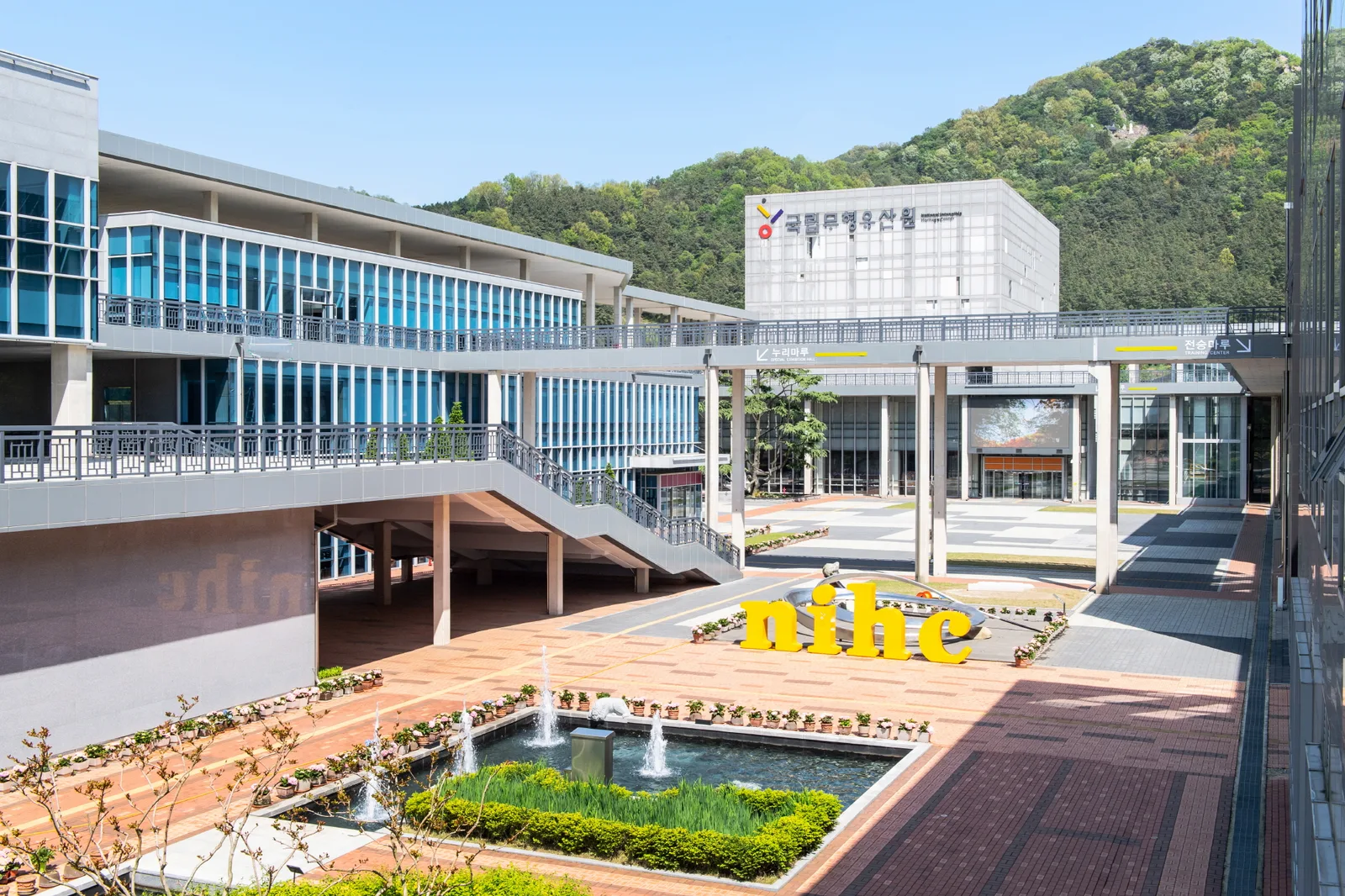 국립무형유산원 건물 외관과 분수, 산자락을 배경으로 한 전경