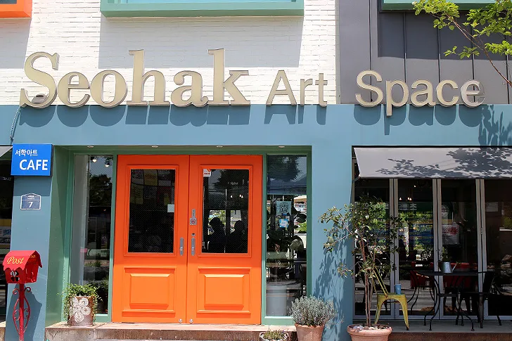서학동예술마을의 오렌지색 문이 있는 갤러리 카페 외관, Seohak Art Space 간판