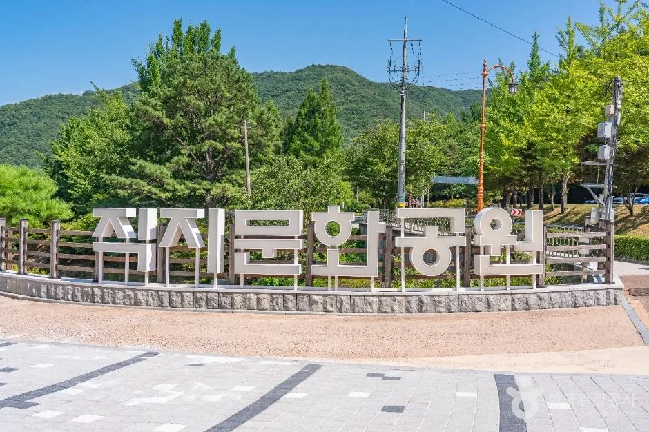 잔디 광장 앞에 직지문화공원 글자 조형물이 세워진 모습