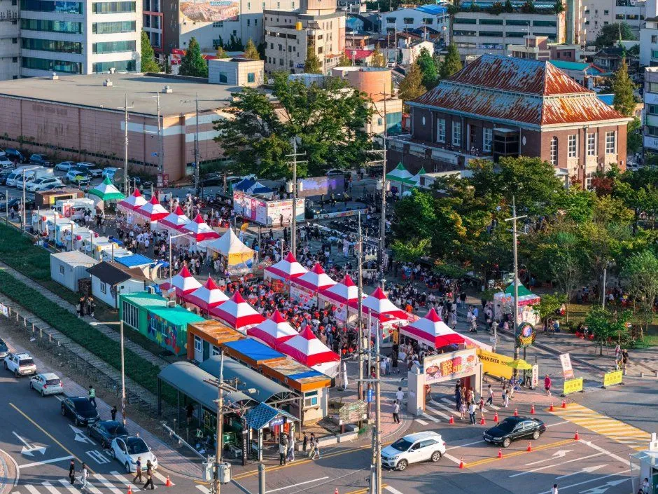 군산 백년광장 일대 도로변에 줄지어 선 짬뽕페스티벌 부스 천막과 인파를 위에서 내려다본 모습