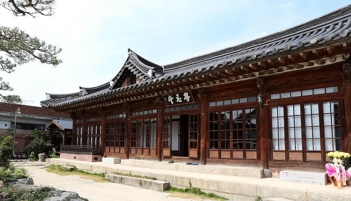 기와지붕과 긴 마루, 현판이 걸린 한옥 건물의 정면과 넓은 마당