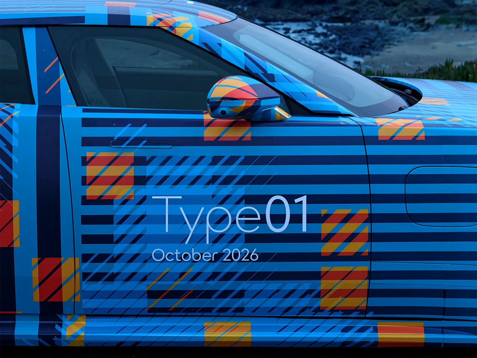 파란색 위장 래핑 재규어 타입 01 프로토타입의 앞문과 사이드미러 클로즈업. 문짝에 Type01 October 2026 표기가 보인다
