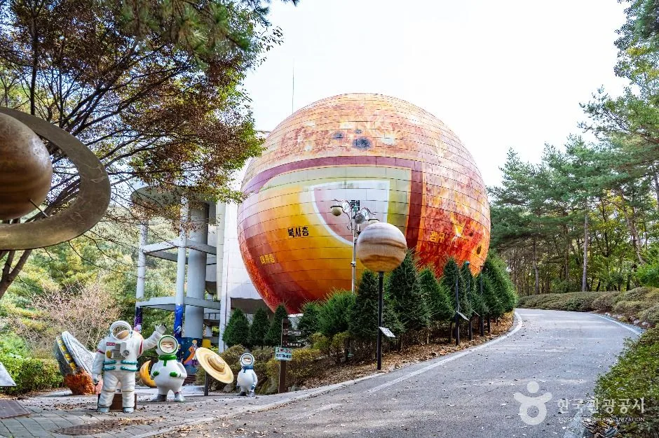 구 모양의 붉은 주황색 건물이 보이는 천문대 진입로 풍경