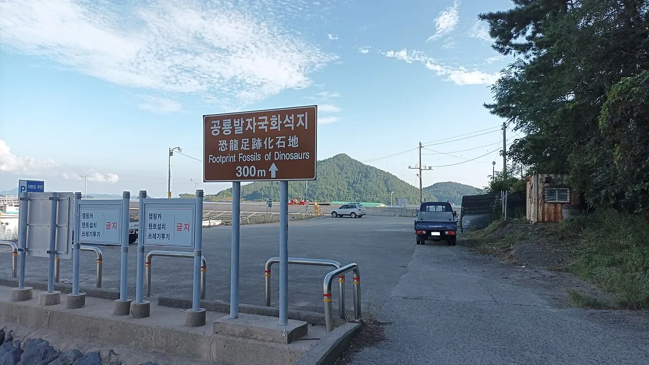 공룡발자국화석지 방향을 안내하는 도로 표지판과 주차장