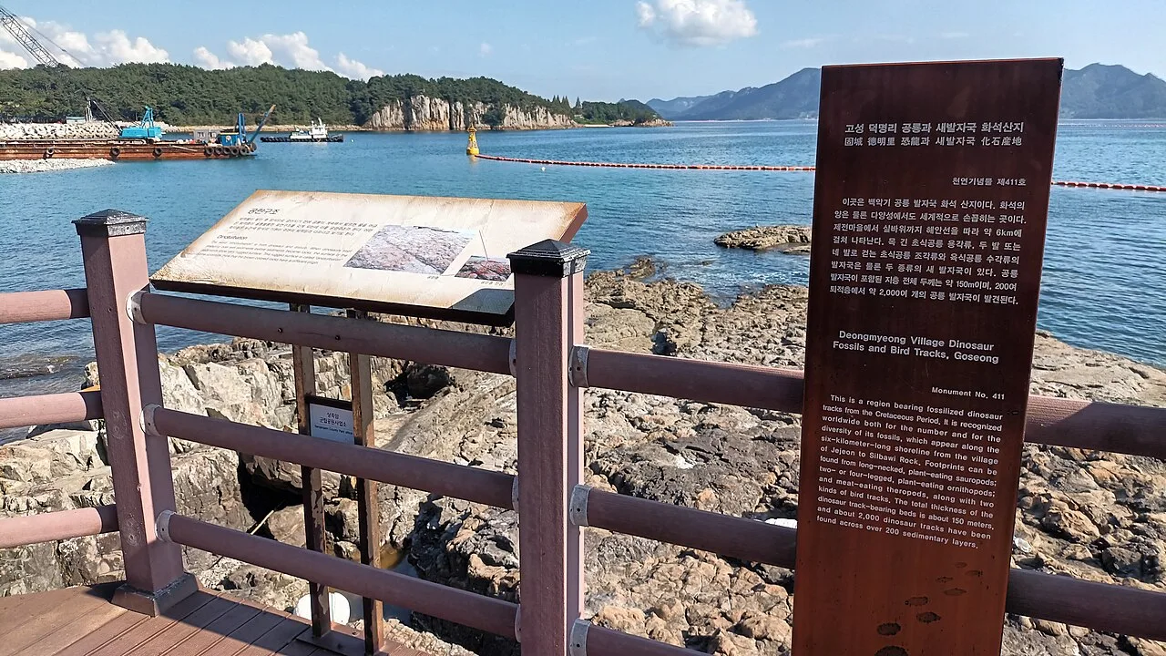상족암 해안 산책로에 설치된 공룡발자국 화석지 안내판과 바다 전망