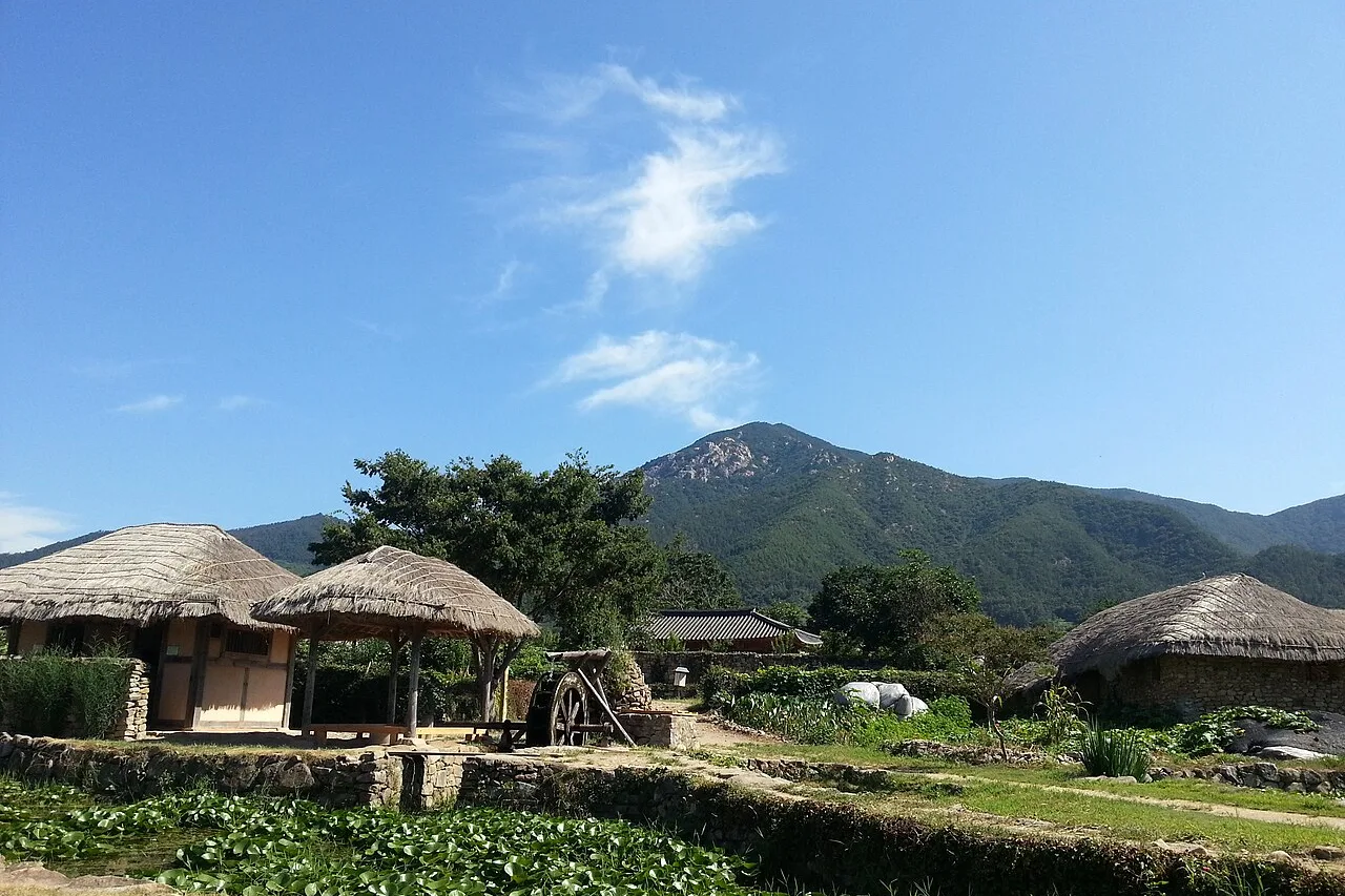 낙안읍성 성곽 안쪽에 늘어선 초가집과 배경의 산세