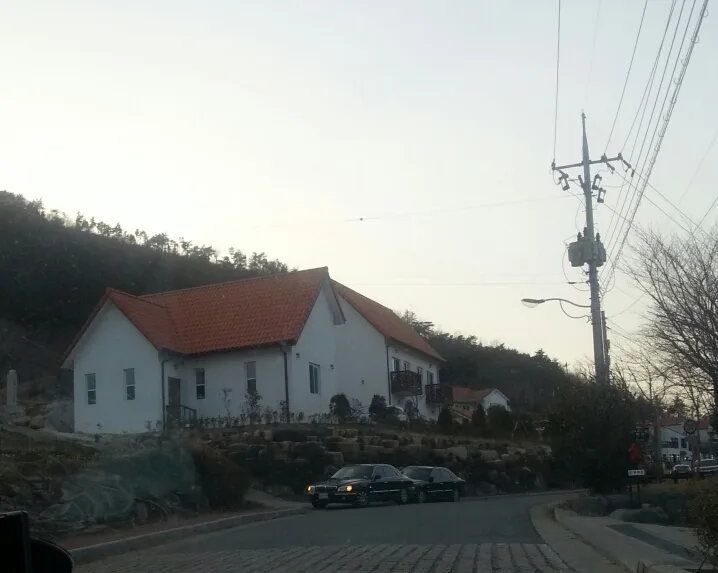 독일마을 언덕길 가장자리에 세워진 차량 두 대
