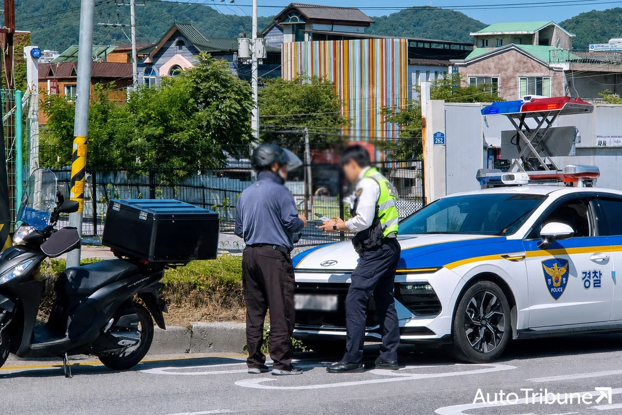 경찰이 이륜차 운전자를 단속하는 모습