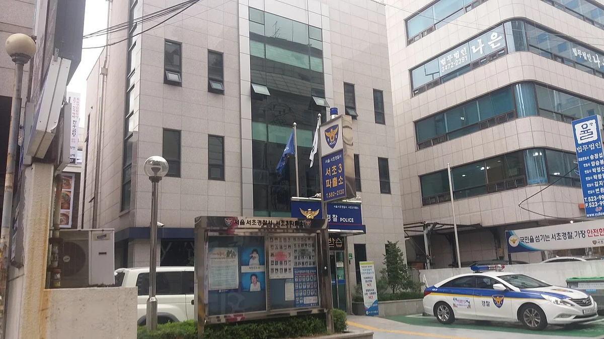 경찰 마크가 붙은 건물 앞에 경찰차가 세워진 파출소 입구