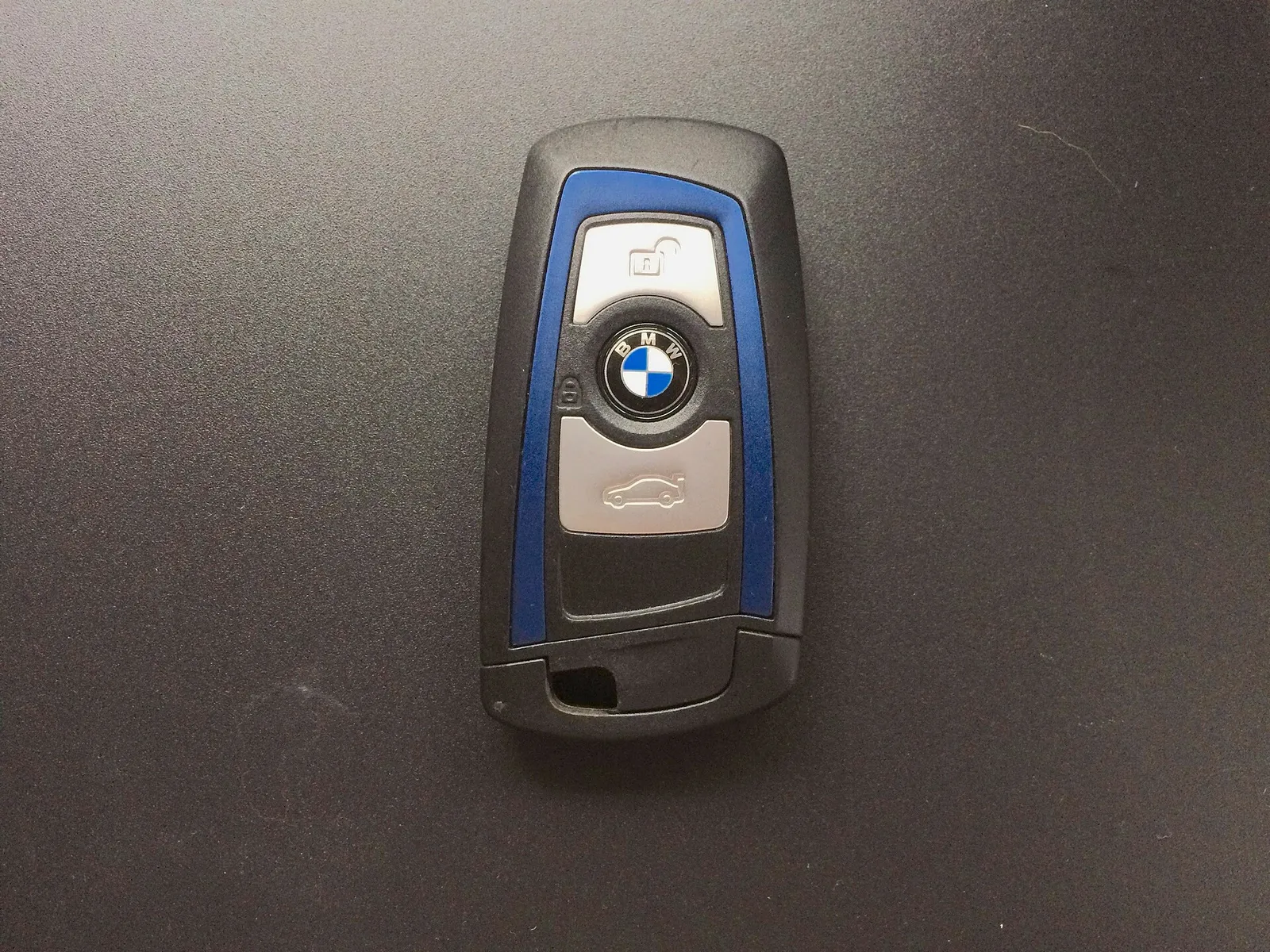 어두운 바탕 위에 놓인 BMW 스마트키 한 개