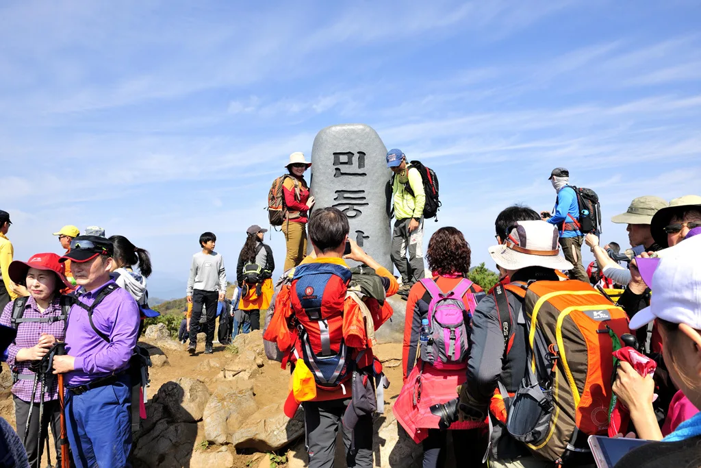 해발 1,119m 민둥산 정상 표지석 앞에서 인증샷을 남기는 등산객들
