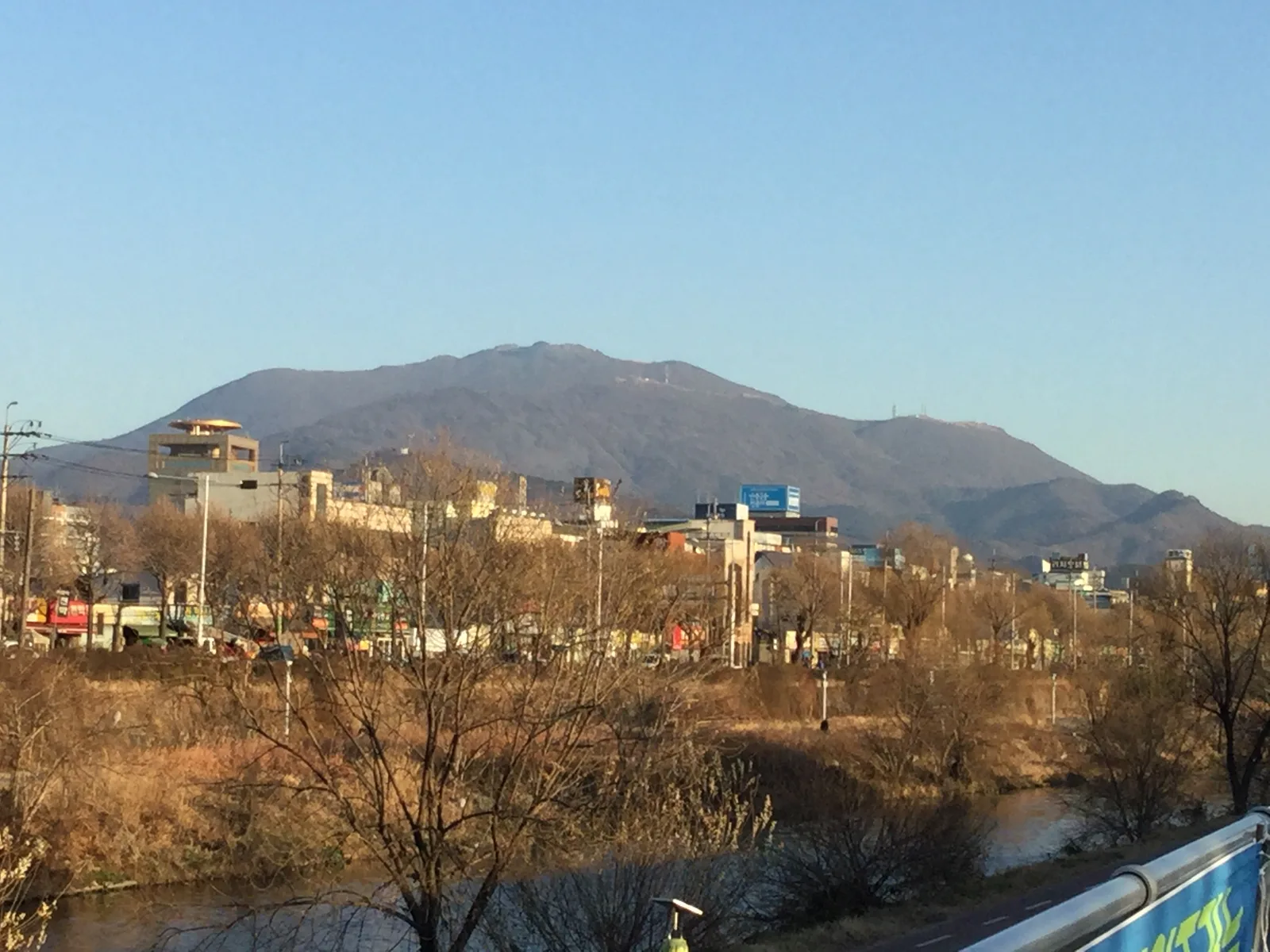 광주 도심 너머로 보이는 무등산 전경, 겨울 저녁 노을빛 아래 도시와 산이 함께 펼쳐진 모습