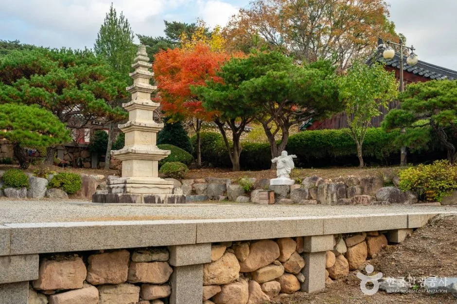 단풍 든 나무들 사이로 오층 석탑이 서 있는 사찰 마당