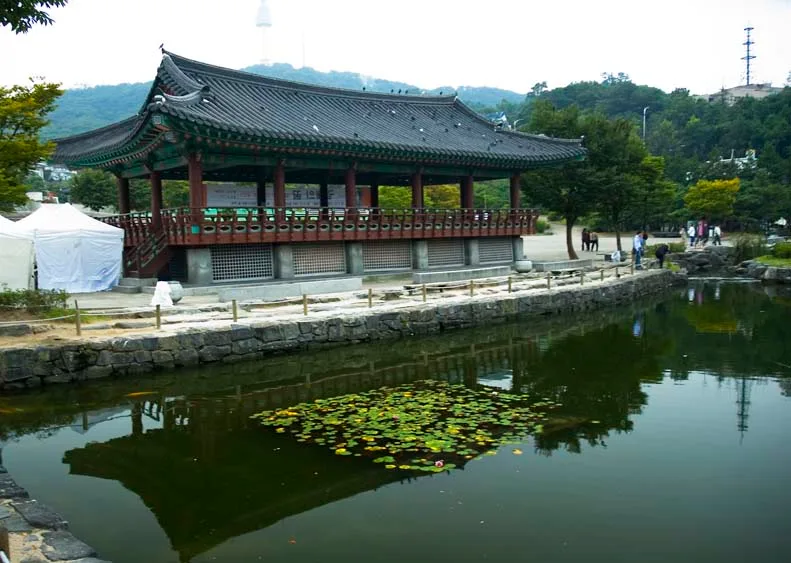 남산골한옥마을 연못가에 자리한 정자, 뒤로 N서울타워가 보인다